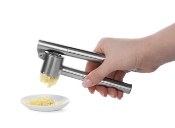 Woman squeezing garlic with press on white background, closeup