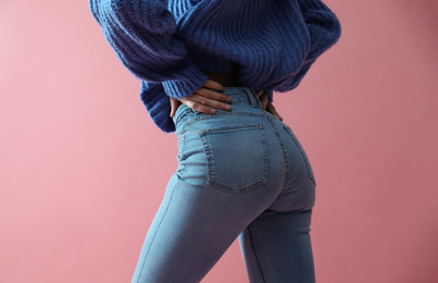 Photo of Woman wearing jeans on pink background, closeup