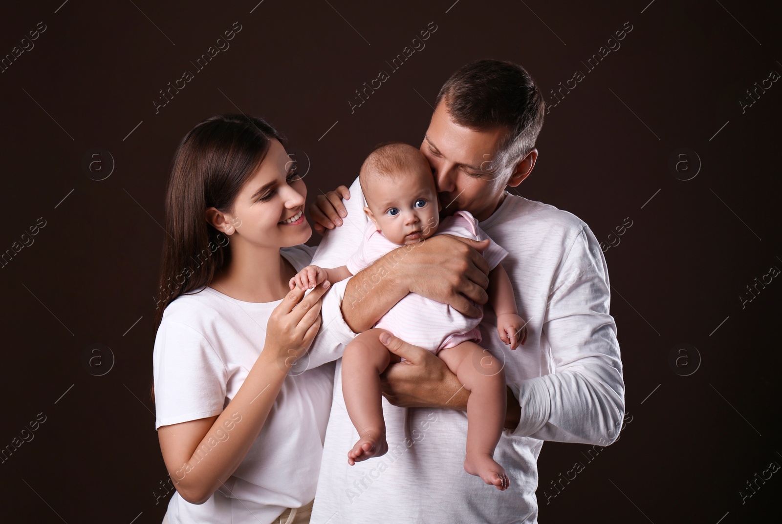 Photo of Happy family with little baby on dark background