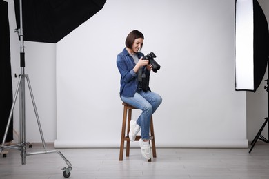 Photo of Professional photographer with camera in modern photo studio