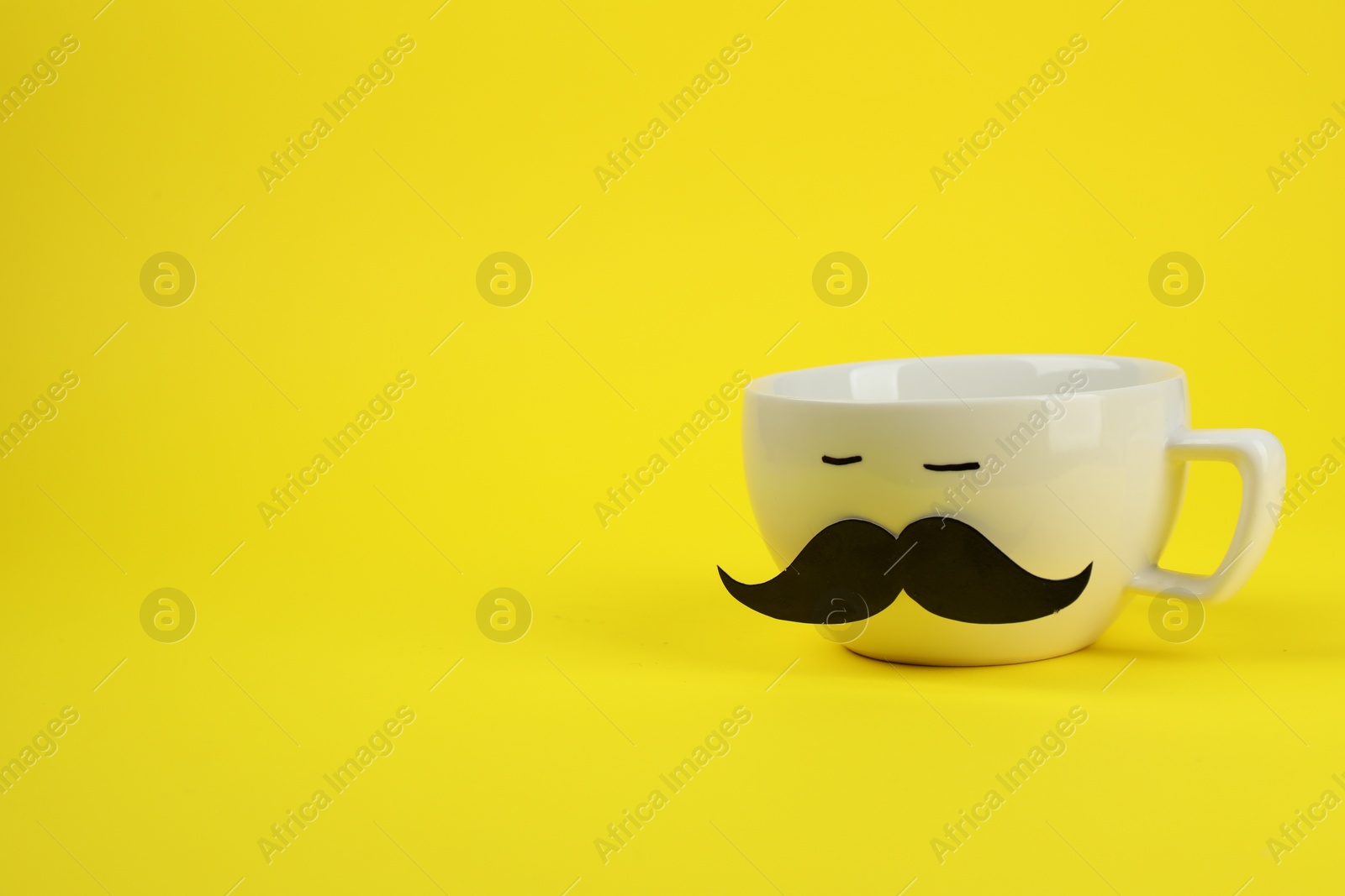 Photo of Man's face made of cup and fake mustache on yellow background. Space for text