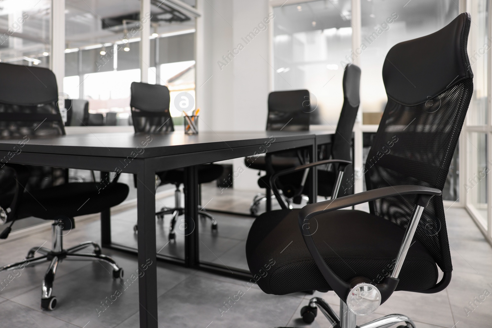 Photo of Comfortable office chairs and tables in meeting room