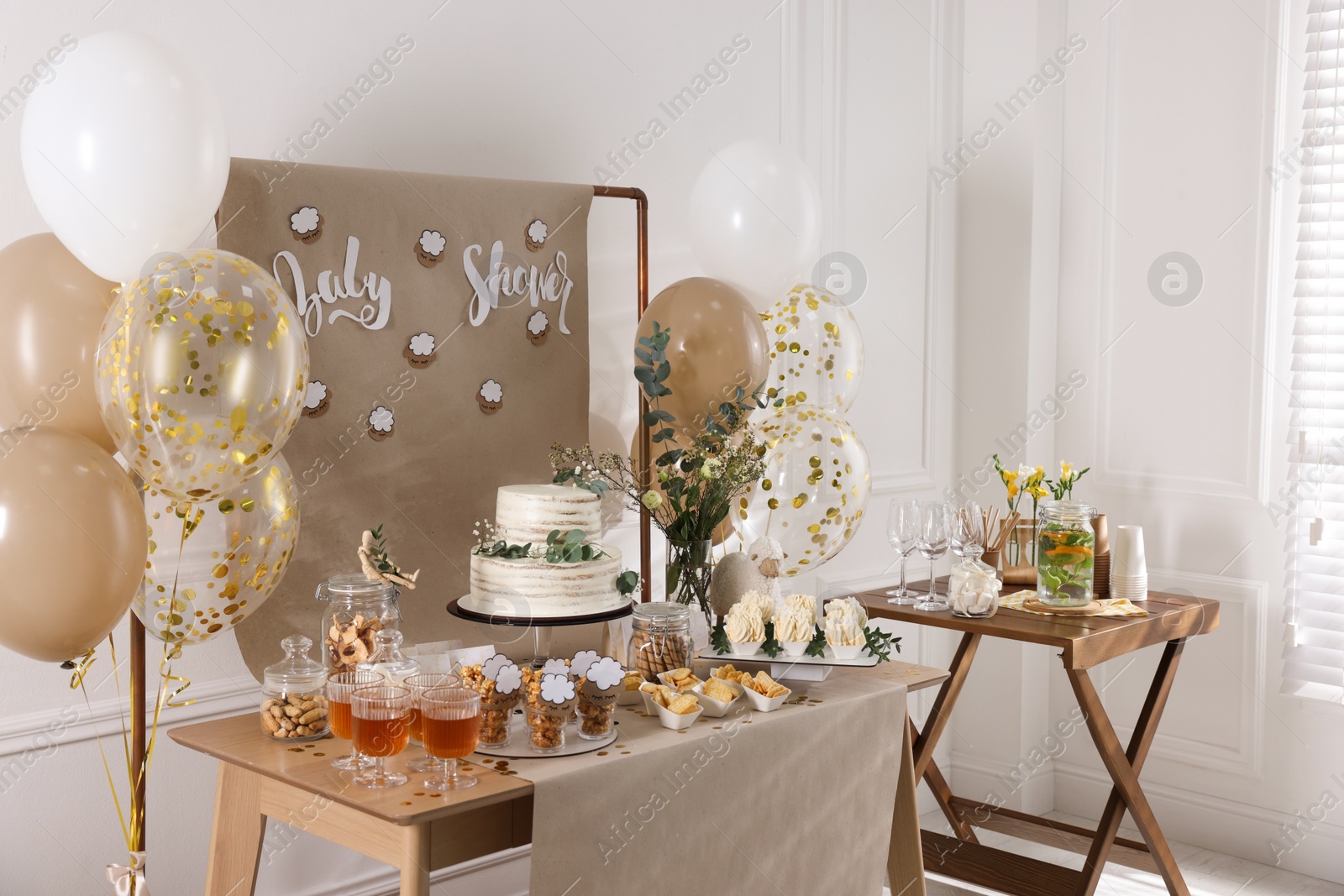 Photo of Beautiful cake and other treats on table in room. Baby shower party