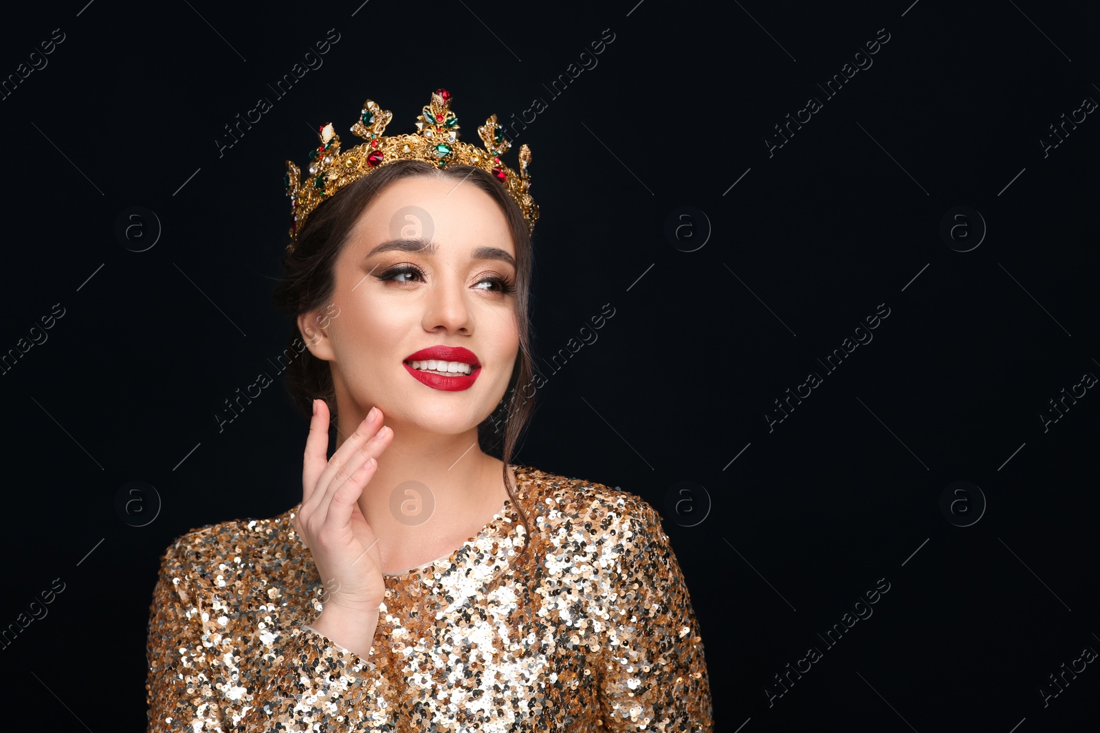 Photo of Beautiful young woman wearing luxurious crown on black background, space for text