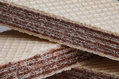 Photo of Delicious crispy wafers with chocolate filling as background, closeup view