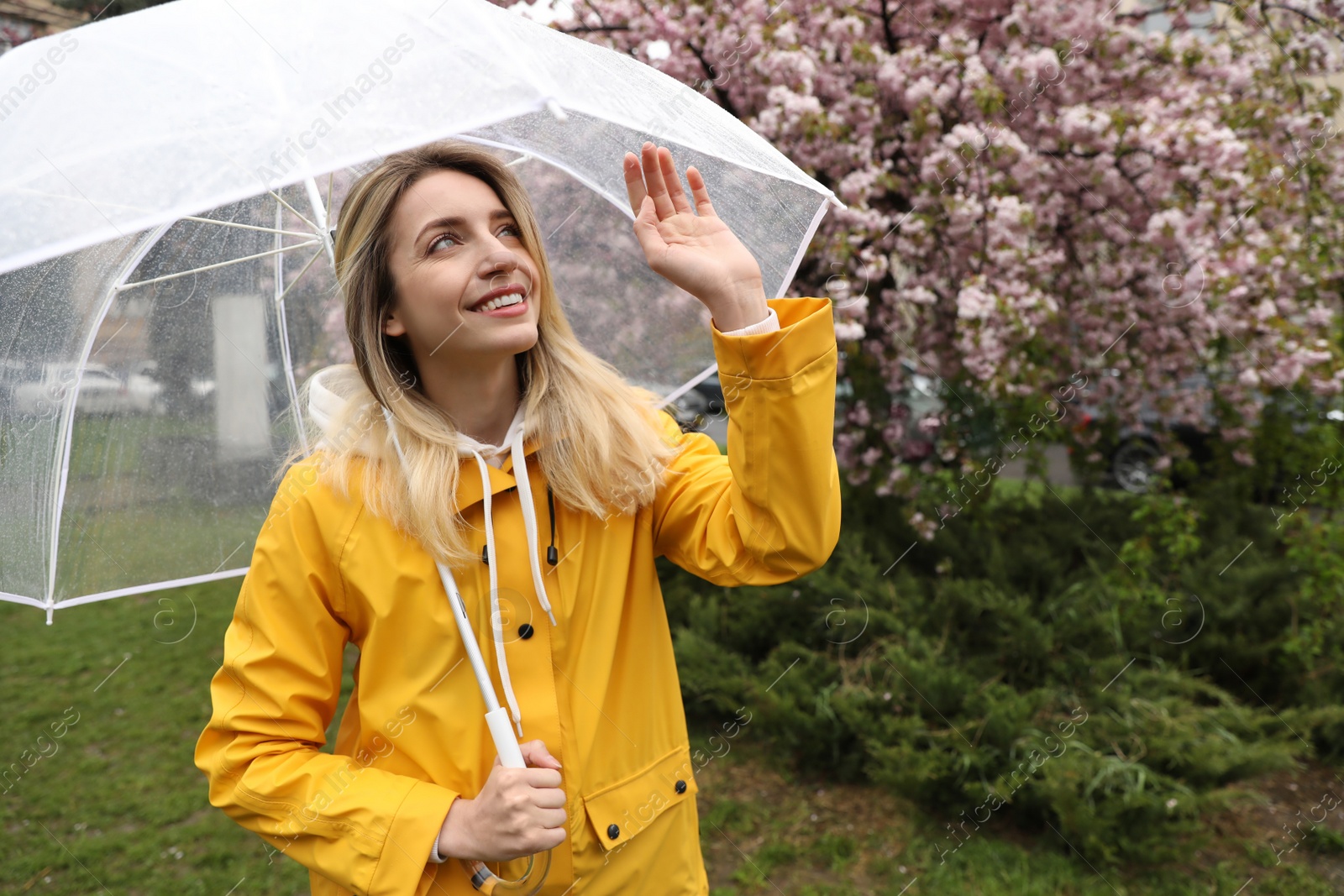 Photo of Young woman with umbrella in park on spring day