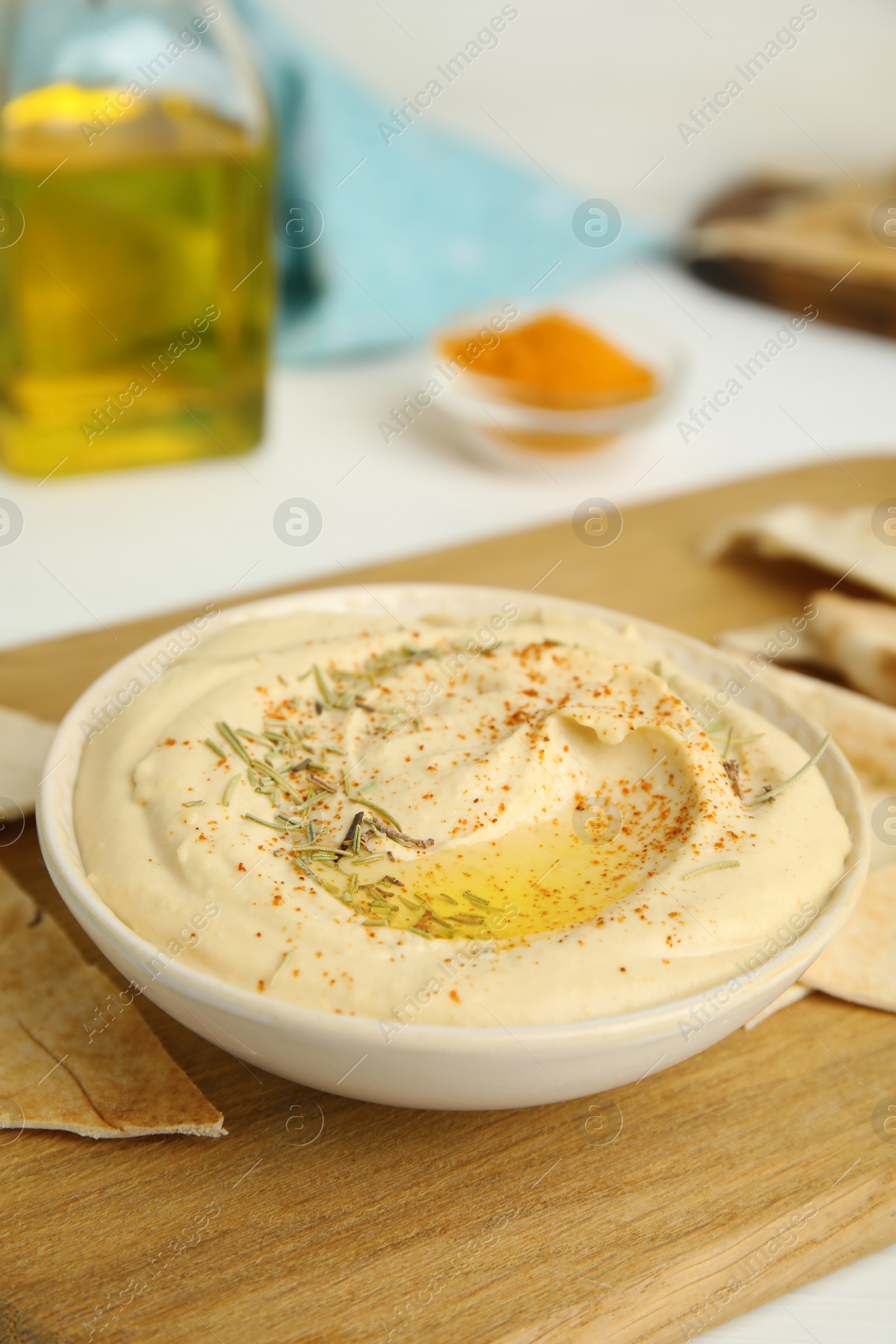 Photo of Delicious hummus served with pita chips on wooden board