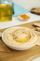 Delicious hummus served with pita chips on wooden board