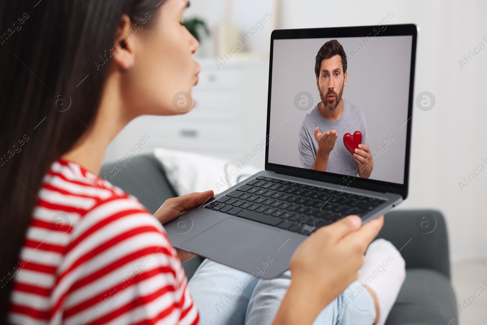 Image of Long distance love. Woman having video chat with her boyfriend via laptop at home