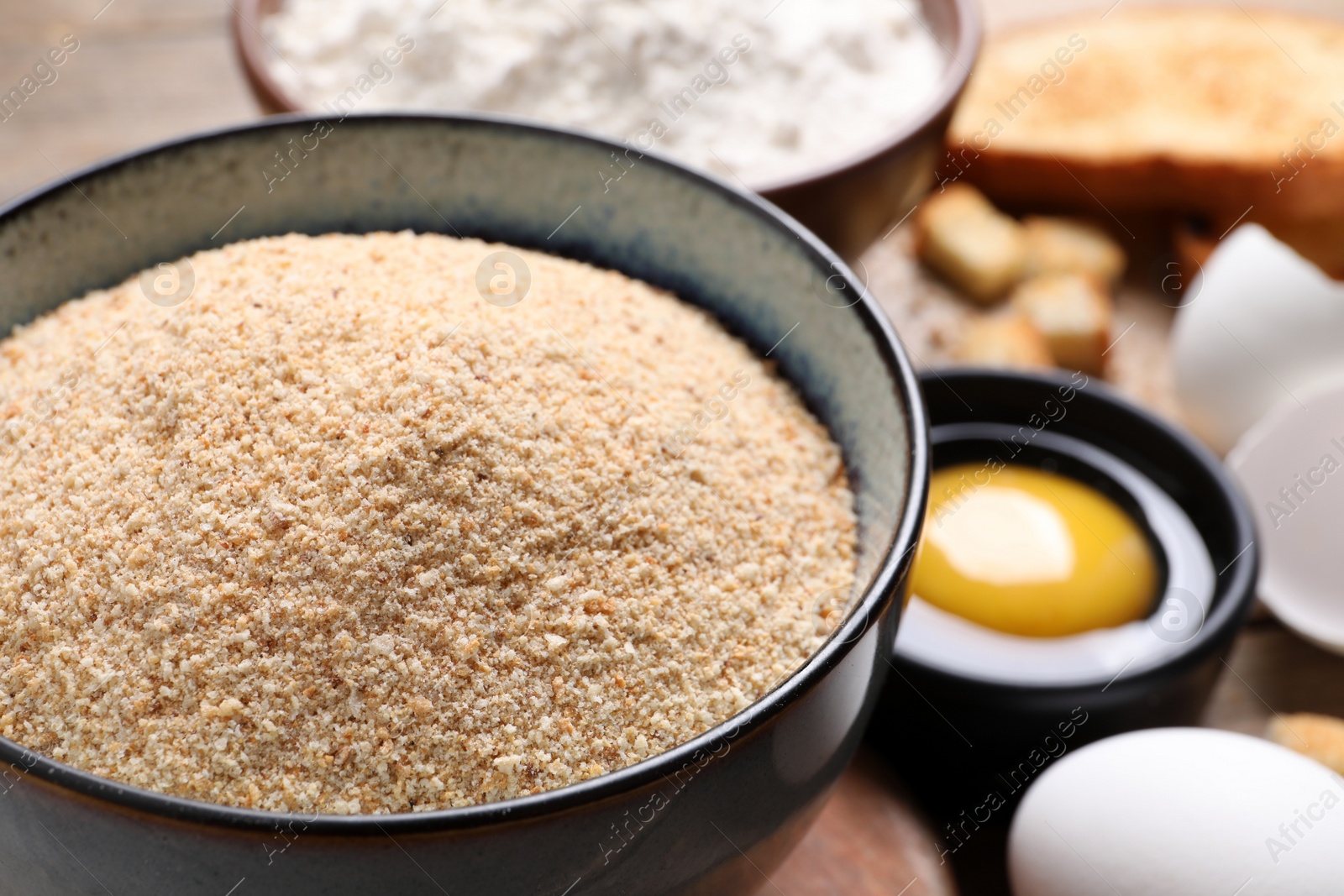Photo of Fresh breadcrumbs and egg on table, closeup