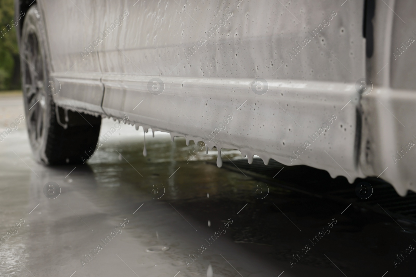 Photo of Auto with cleaning foam at car wash, closeup