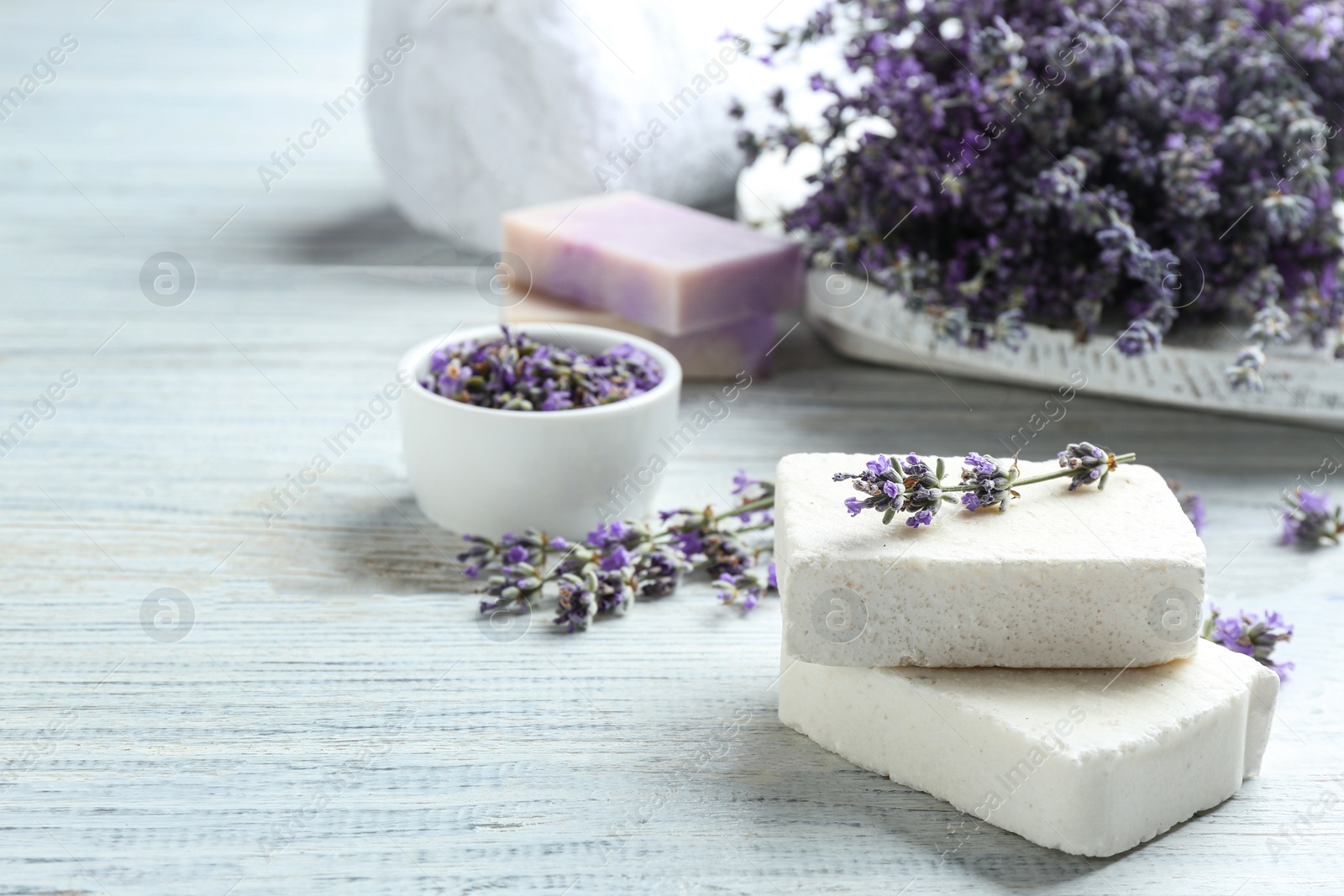 Photo of Handmade soap bars with lavender flowers on white wooden table. Space for text