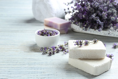 Handmade soap bars with lavender flowers on white wooden table. Space for text