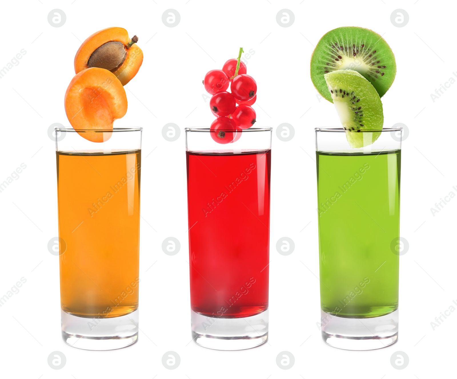 Image of Different freshly made juices on white background. Fruits falling into glasses