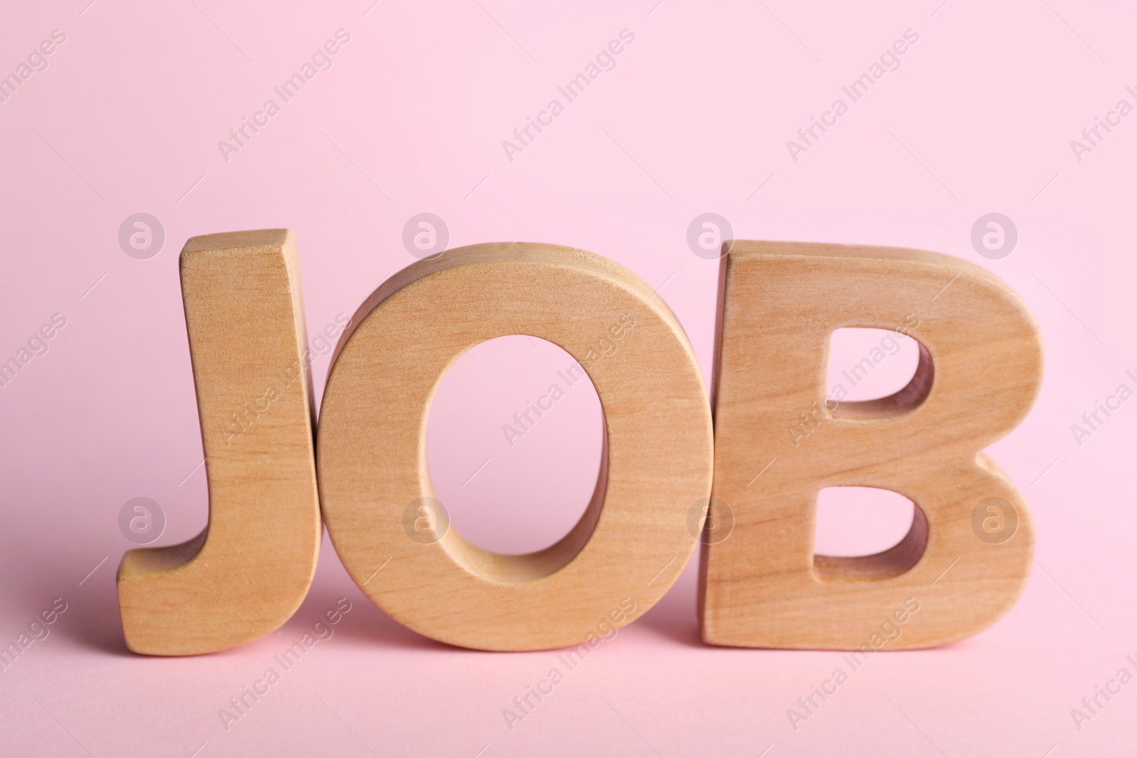 Photo of Word JOB made with wooden letters on pink background. Career concept