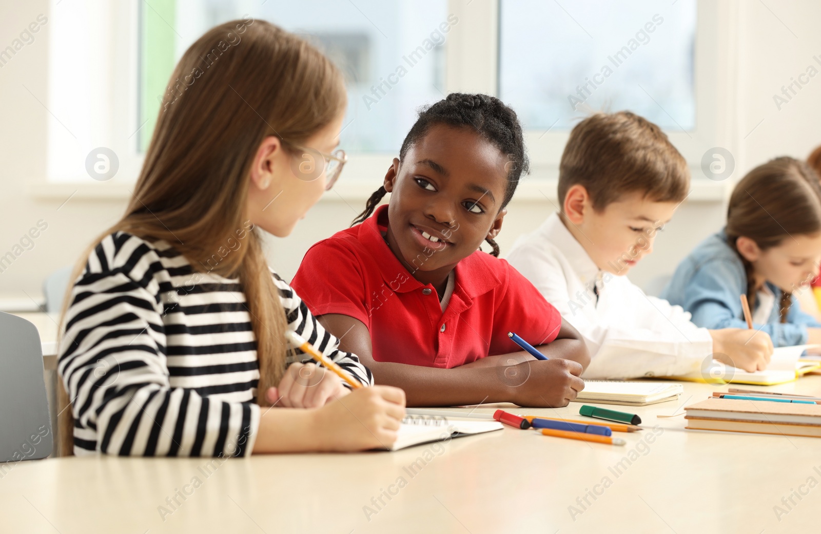 Photo of Cute children studying in classroom at school