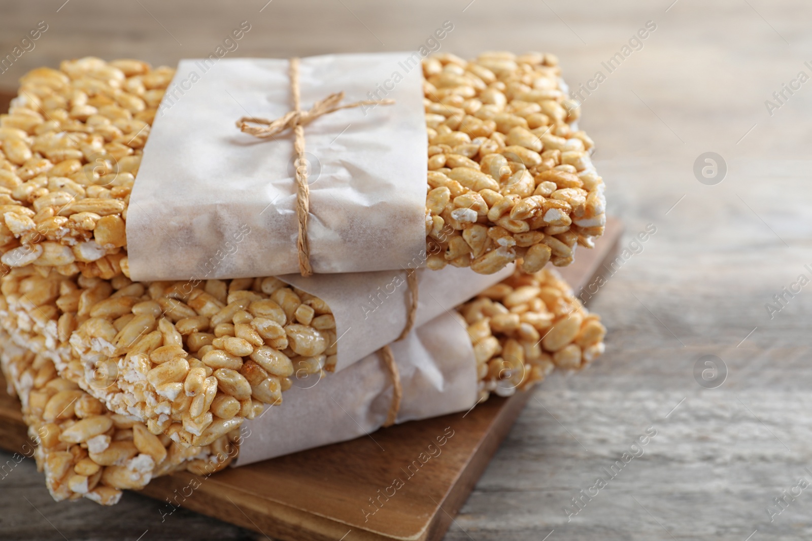 Photo of Delicious rice crispy treats on wooden table, closeup