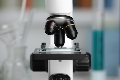 Photo of Modern medical microscope with glass slide on blurred background, closeup