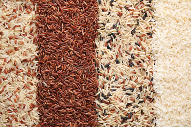 Photo of Different types of rice as background, top view