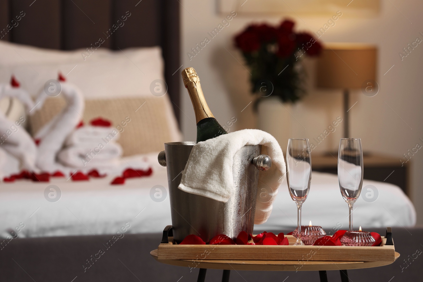 Photo of Honeymoon. Sparkling wine and glasses on wooden table in room