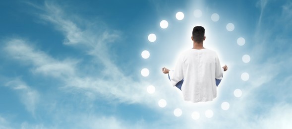 Image of Man meditating in blue sky, back view. Banner design with space for text