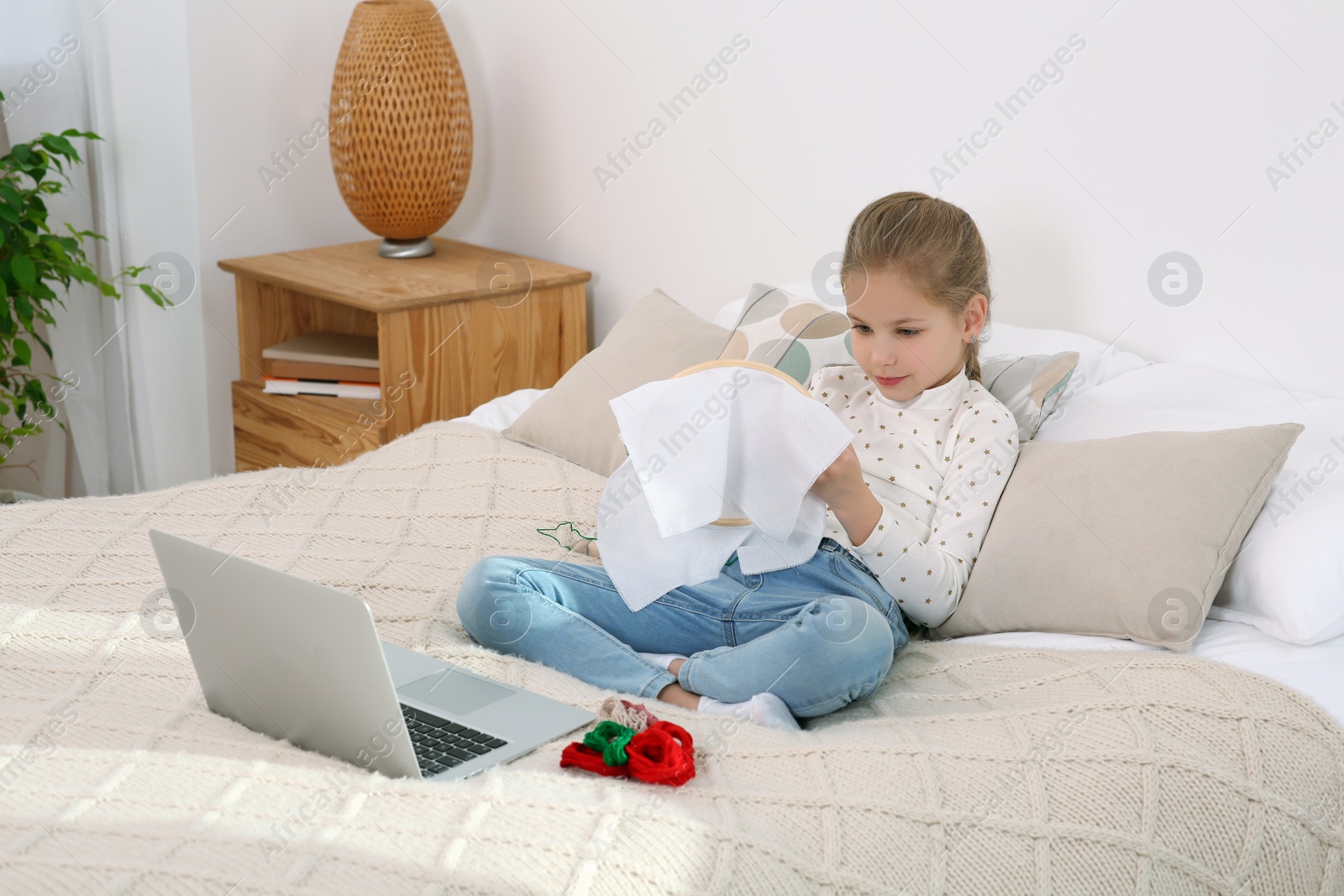 Photo of Little girl learning to embroider with online course at home. Space for text