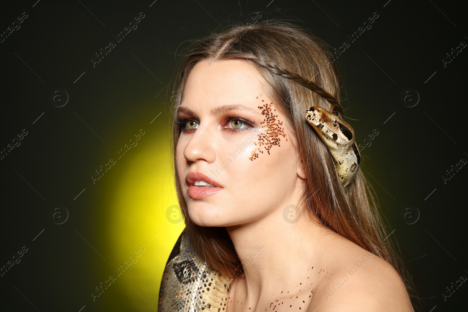 Photo of Beautiful woman with boa constrictor on color background