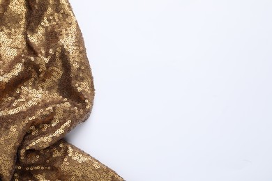 Photo of Golden shiny sequin fabric on white background, top view. Space for text