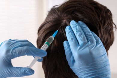 Trichologist giving injection to patient in clinic, closeup