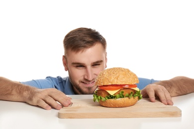 Photo of Young man and tasty burger on white background