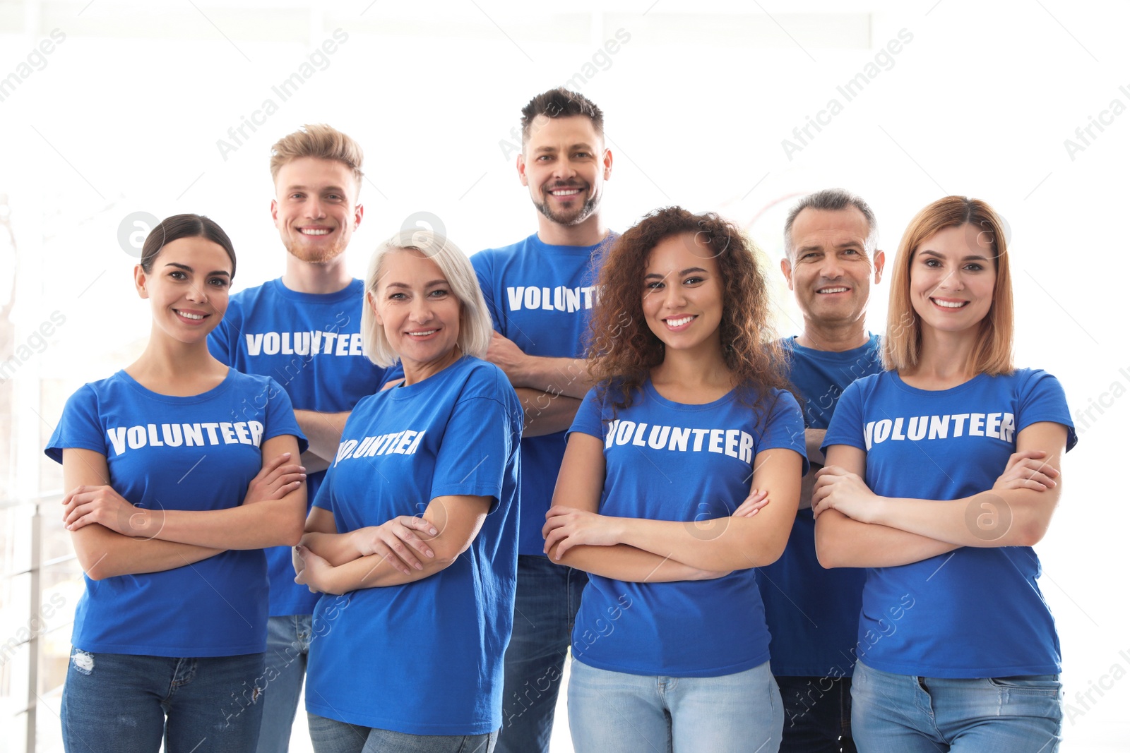 Photo of Team of volunteers in uniform on light background