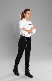 Female security guard in uniform on grey background