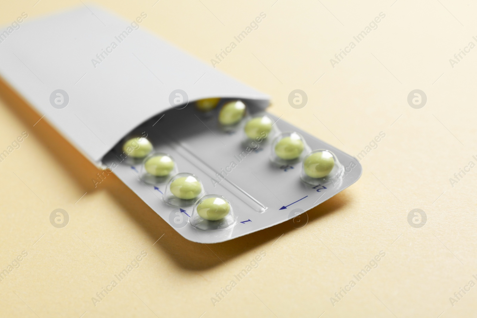 Photo of Birth control pills on beige background, closeup