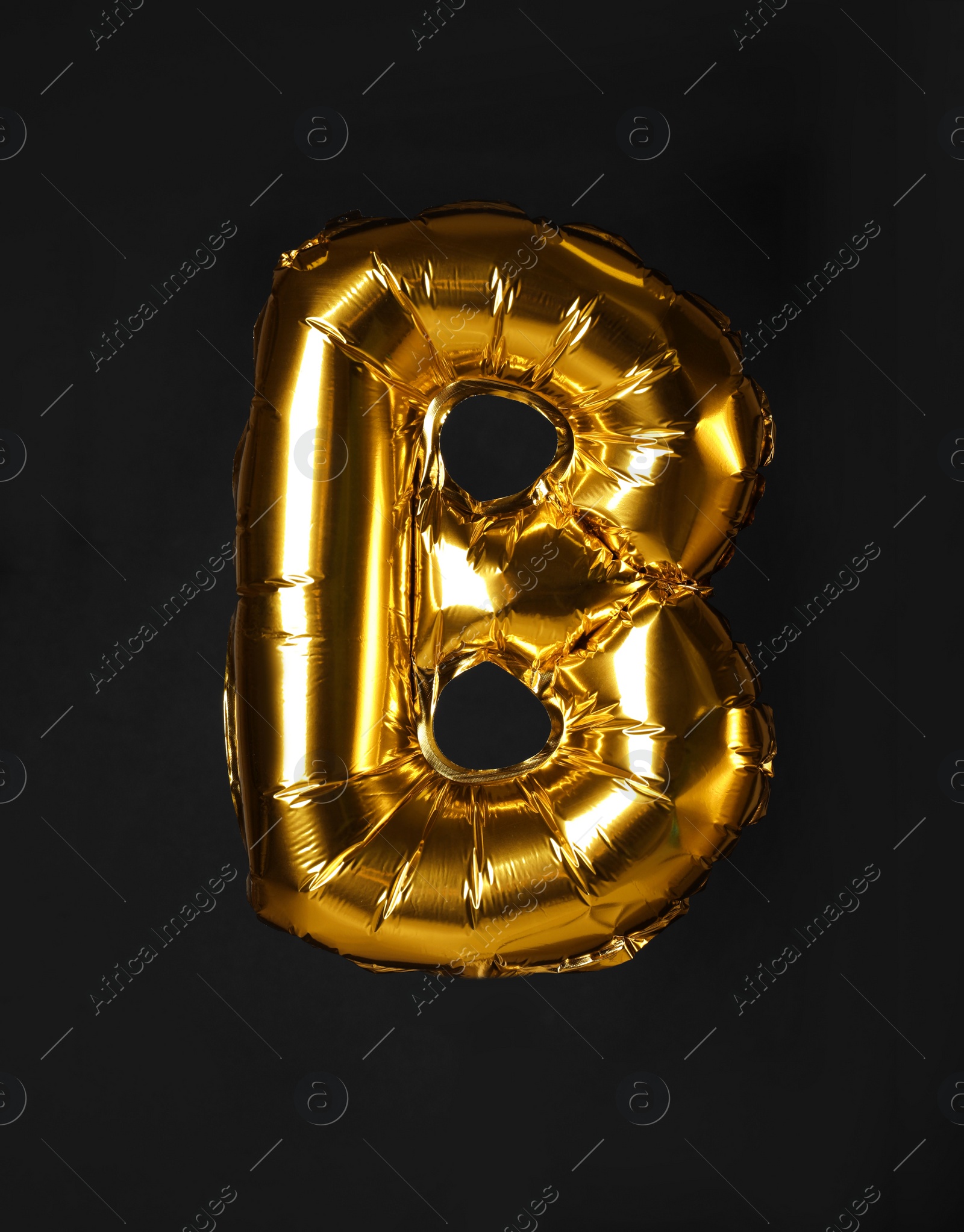 Photo of Golden letter B balloon on black background