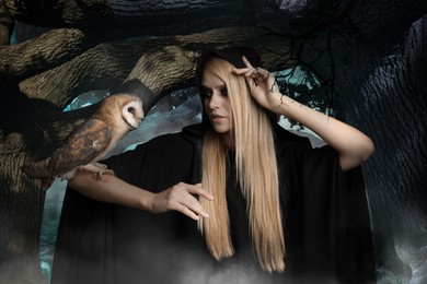 Witch wearing black mantle with owl in foggy forest. Fantasy world