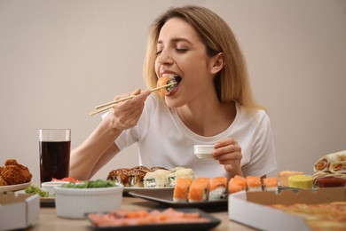 Photo of Food blogger eating at table against beige background. Mukbang vlog