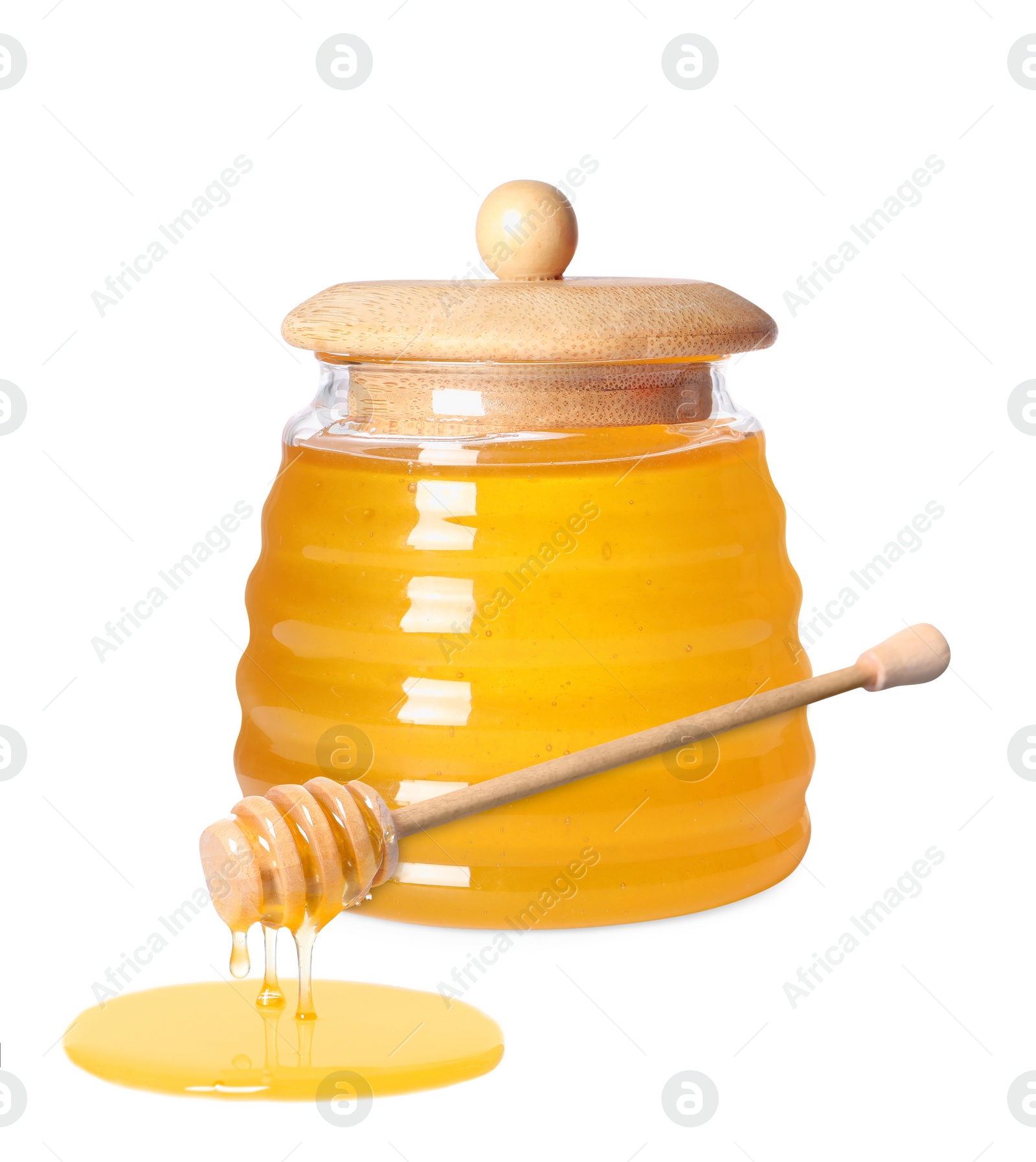 Image of Natural honey dripping from dipper. Jar full of honey on white background