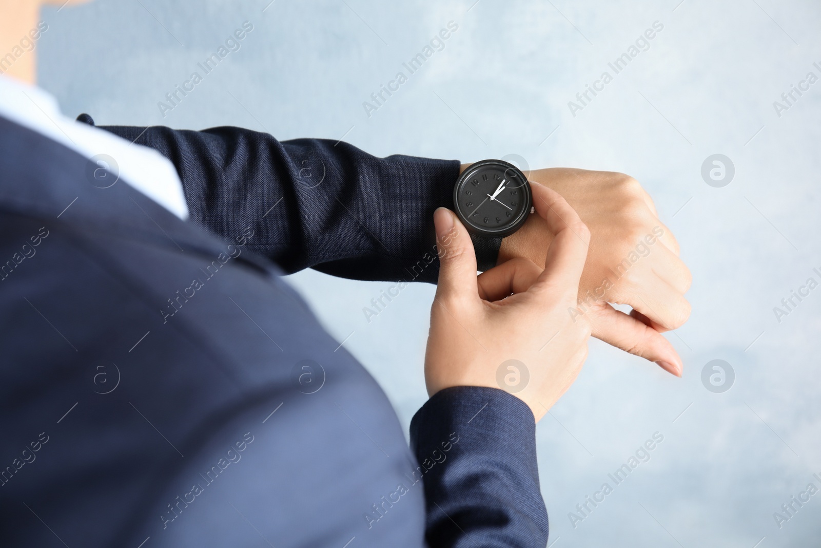 Photo of Businesswoman with stylish wrist watch on color background, closeup. Time management