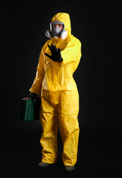 Photo of Man in chemical protective suit on black background. Virus research