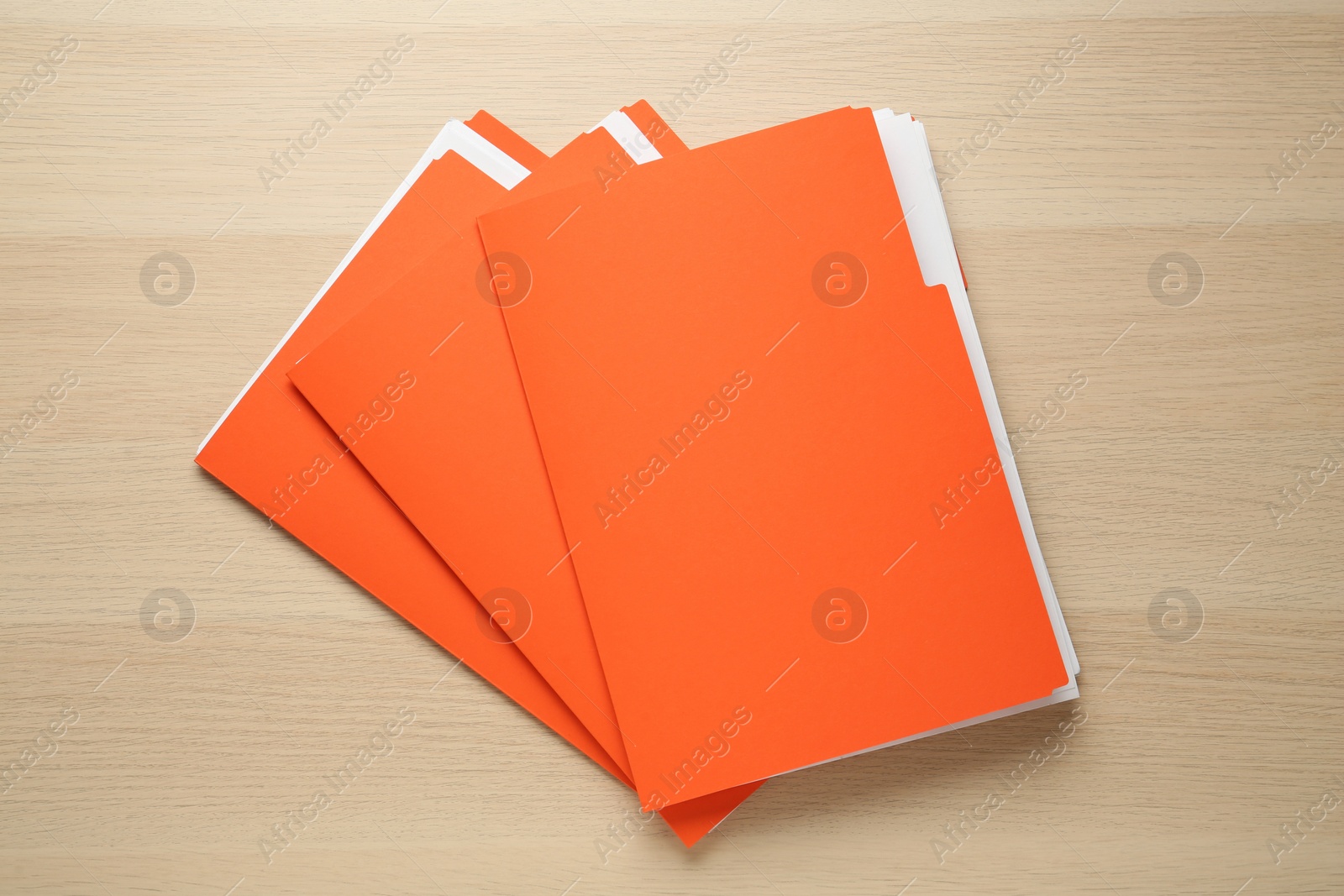 Photo of Orange files with documents on wooden table, top view