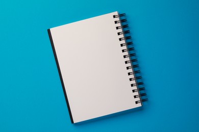 Blank notebook on light blue background, top view