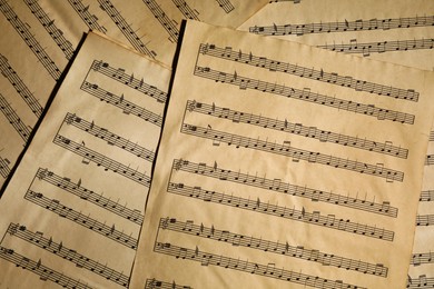 Many old note sheets as background, top view