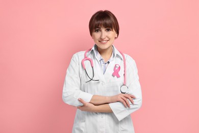 Photo of Mammologist with pink ribbon on color background. Breast cancer awareness