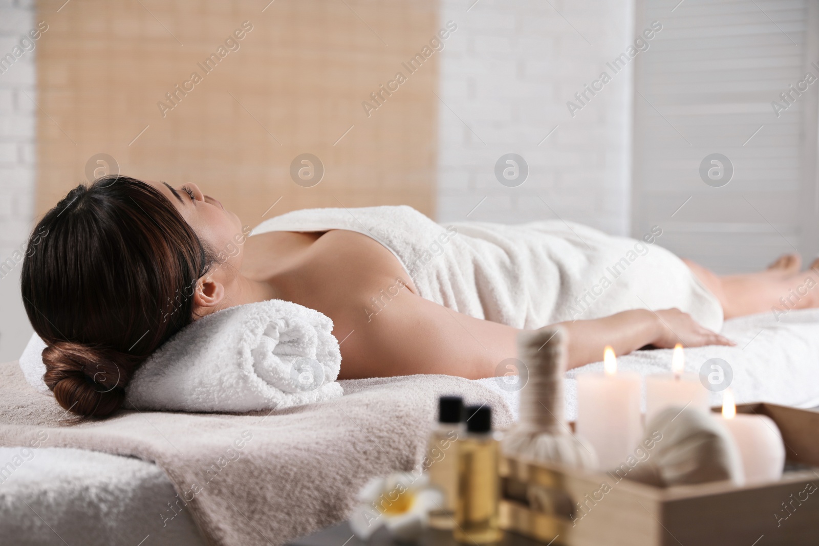 Photo of Beautiful Asian woman lying on massage table in spa salon