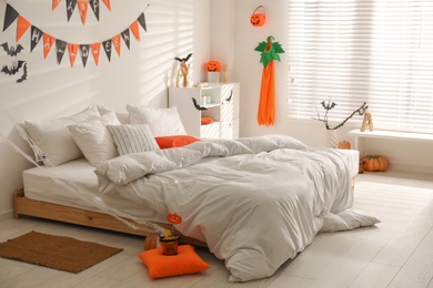 Stylish bedroom interior with festive Halloween decor