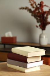 Many books stacked on wooden table indoors, space for text