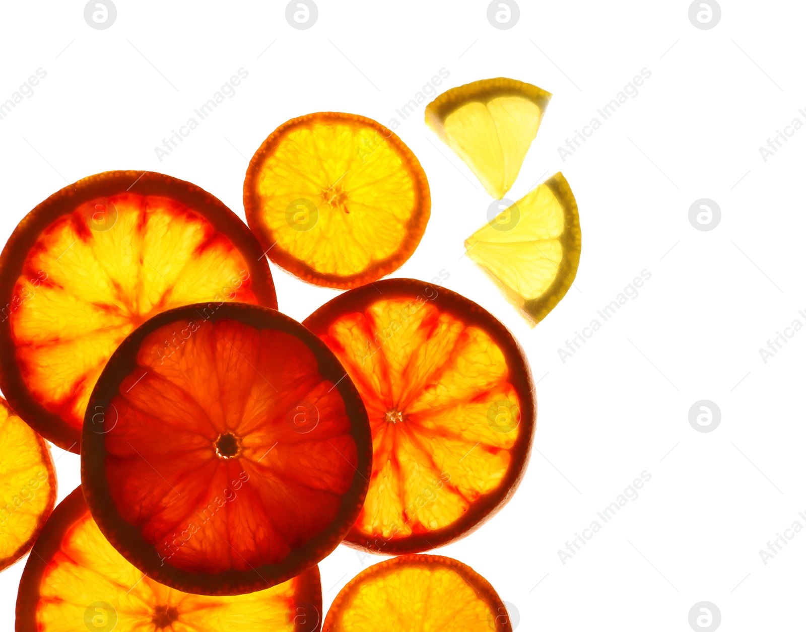 Photo of Illuminated slices of citrus fruits on white background, top view