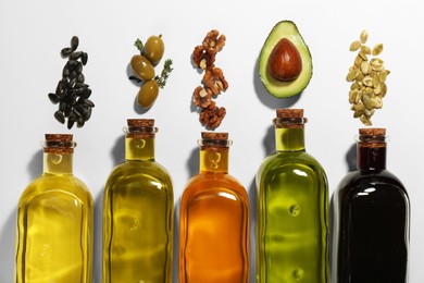 Vegetable fats. Different cooking oils in glass bottles and ingredients on white background, flat lay