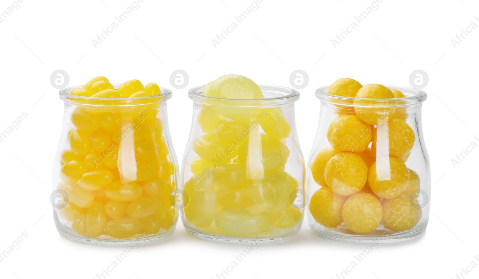 Photo of Different tasty lemon drops in jars isolated on white