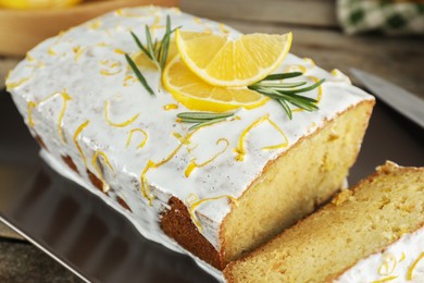 Tasty lemon cake with glaze on table, closeup